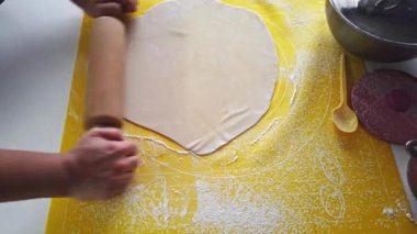 Ev yapımı hamur tatlısı yapma sanatına dikkatle bakın. Bir kadın, sıcak ve davetkar bir mutfakta ustalıkla hamur işi yapar..