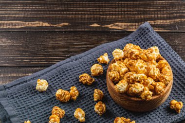 Atıştırmalık konsepti, tatlı karamelize patlamış mısır gri, ahşap arka planda bir kasede yüksek kaliteli fotoğraf..