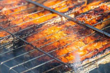 Taze somon ve alabalık ızgarada cızırdıyor, dumanlı aromalı. Barbekü dışarıda yapılıyor, güneşli bir günün ve lezzetli deniz ürünlerinin tadını çıkarmak için mükemmel..