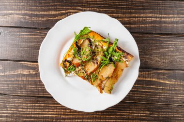 Nefis bir dilim ev yapımı pizza vitrinleri süzme peynir, armut ve taze roka karışımı. Lezzetli bir atıştırmalık için mükemmel. Sıcak bir mutfak ortamında keyif aldım..