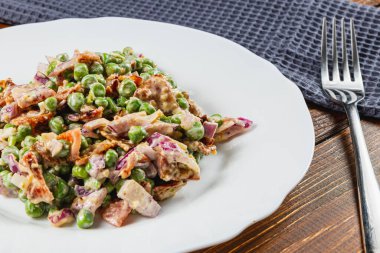 Bu canlı salatada taze bezelyeler, çıtır çıtır soğanlar ve tatlı mor soğanlar ustalıkla birleştirilmiş. Köy tabaklarında servis edilir, taze ve sağlıklı bir yemeği somutlaştırır..