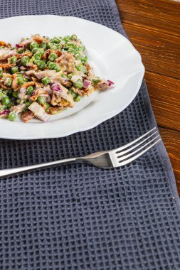 Taze bezelye, soğan ve canlı mor soğandan yapılmış lezzetli bir salata yanında gevrek tam tahıllı ekmek servis edilir. Hafif bir öğle veya akşam yemeği için mükemmel..