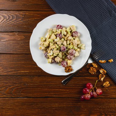 Taze ve iştah açıcı bir salatada taze tavuk filetosu, sulu üzümler, gevrek cevizler ve Yunan yoğurdu ile birlikte gevrek kereviz yer alıyor. Hafif bir öğle yemeği için mükemmel..