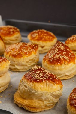 Sıcak hamur işleri fırından çıkar, pullu katmanları altın bir parıltıyla parlar. Çıtır çıtır çerezler susam tohumları serpiştirilir, herkesi lezzetli aromalarının tadını çıkarmaya davet eder..