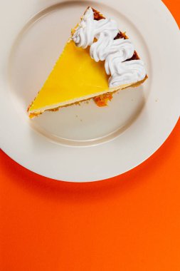 Taze ev yapımı portakallı cheesecake 'in tadını çıkarıyorum. Üstünde kremalı pasta var. Sıcak bir tabakta sıcak bir fincan aromatik espresso ile mükemmel bir şekilde kompliman yapılmış..