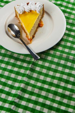 Sıcak bir mutfak masasındaki aromatik espresso kahveyle tamamlanmış kremalı kremalı taze portakallı peynirli kekin tadını çıkar..