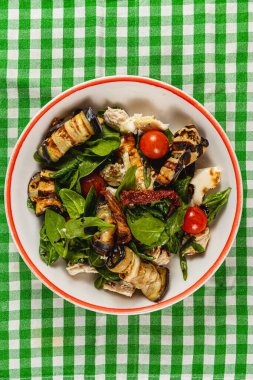 Bu canlı salata ızgara patlıcan, ıspanak ve kiraz domateslerini kareli kumaşın üzerine serpiştirilmiş balzamik sosla birleştiriyor. Sağlıklı bir yemek için mükemmel..