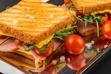 Salamlı ızgara sandviç tabakaları, erimiş peynir ve taze roka, ıspanak ve domates. Hafif bir öğle yemeği ya da brunch için mükemmel, çıtır çıtır bir dokuya sahip..