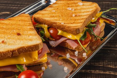 Eritilmiş peynir, jambon, ıspanak, roka ve domatesli iki lezzetli tost ekmeği. Günün her saatinde iştah açıcı veya yemek için mükemmel..