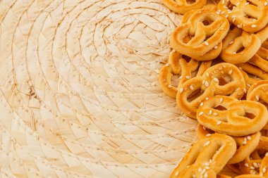 Susamlı krakerler sanatsal olarak dokuma sepetine konur. Detaylar çıtır çıtır yiyeceklerin dokusunu ve rengini gösteriyor..