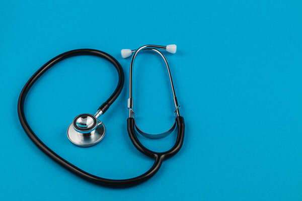A stethoscope rests on a vibrant blue background, highlighting the importance of medical awareness and health care initiatives aimed at cancer prevention and support for patients.