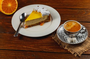 Bir dilim taze ev yapımı portakallı cheesecake, kremayla süslenmiş, yanında da aromatik espresso kahvesi. Sıcak bir ikindi ikramı için mükemmel..