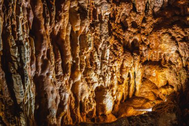 Yumuşak ışık, mağara duvarlarının karmaşık dokularını aydınlatarak çarpıcı kaya oluşumlarını ortaya çıkarır. Gölgeler bu yeraltı uzayındaki doğal güzellikleri ve jeolojik özellikleri vurgular..