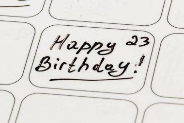 A handwritten note wishing a happy 23rd birthday is displayed on a white surface. The message features playful cursive lettering, adding a personal touch to the celebration. clipart