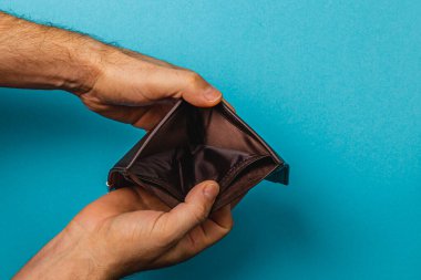 Bir umutsuzluk anında, bir erkek işadamı, mali mücadelenin zorluklarını ve durgunluğun kişisel tasarruflar ve istikrar üzerindeki etkisini gösteren boş cüzdanını inceliyor..