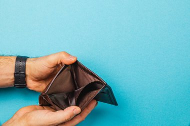 Erkek bir işadamı, mali durumundan duyduğu üzüntüyü ifade eden boş bir cüzdan taşıyor. Katıksız karşıtlık, ekonomik durgunluğun ve kişisel mali kayıpların derin etkisini gösteriyor.