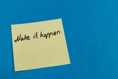 Üzerinde el yazısı olan sarı yapışkan bir not mavi arka plana karşı harekete geçmeye teşvik ediyor. Not olumlu bir zihniyeti teşvik ediyor ve inisiyatif alıyor..