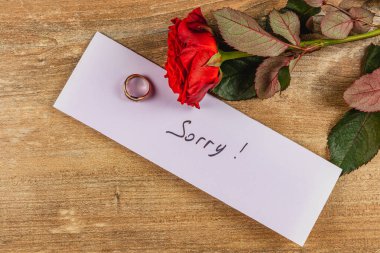 Kırık bir nişan, kayıp aşk ve pişmanlığın özünü yakalayan bir gül ve yüzükle birlikte el yazısıyla yazılmış bir notla ifade edilir..