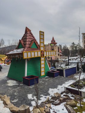 Yaremche Ukrayna 21.01.25 kış boyunca bir parkta kar parçalarıyla çevrili eğlenceli bir yel değirmeni yapısı bulunur. Bina canlı renkler ve eşsiz bir tasarım içeriyor. Soğuğa cazibe katıyor..