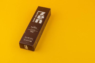 24.03.25 Lviv Ukrayna Keratin içeren bir kutu saç rengi ürünü. Paket belirgin bir şekilde canlı sarı bir arkaplan üzerinde sergileniyor, tasarımı ve markalaşması vurgulanıyor.
