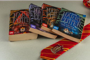 25.03.25 Lviv Ukrayna 'da Fransızca ve Bulgarca dört Harry Potter kitabı, Hogwarts kravatının yanında düzenlenerek büyülü bir edebiyat ve temalı aksesuar koleksiyonu sergileniyor..