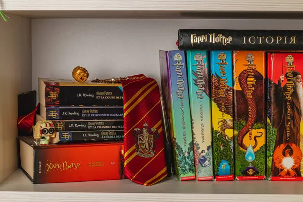 25.03.25 Lviv Ukrayna Bir küratörlü koleksiyon Harry Potter kitaplarının yanı sıra bir Hogwarts kravatı, bir madalyon ve rafta dinlenen temalı aksesuarlar gibi çeşitli dillerde aksesuarlar ortaya koymaktadır..