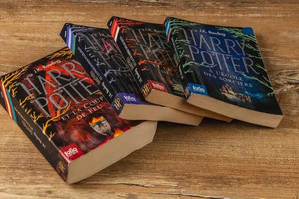 25.03.25 Lviv Ukrayna Tahta bir masada sergilenen Harry Potter kitapları koleksiyonu. Fransızca ve Bulgarca sürümlerinde renkli kapaklar sergileniyor ve düzgünce istifleniyor, okuyucular davet ediliyor.
