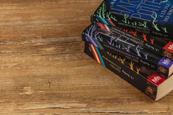 25.03.25 Lviv Ukrayna. Harry Potter kitaplarından oluşan bir kolleksiyon basit bir tahta masanın üzerinde duruyor. Her cilt güzel çizilmiş, canlı renkler ve farklı tasarımlar sergiliyor..