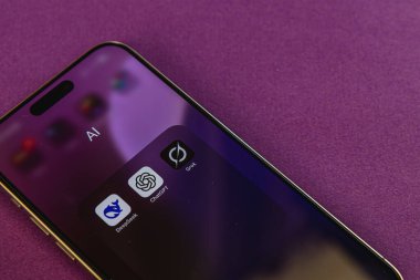 03.26.25 Lviv Ukrayna Mor arkaplanlı bir akıllı telefon, yapay zeka araçları, teknolojiyi ve modern iletişimi vurgulayan simgeler de dahil olmak üzere çeşitli uygulamaları gösteriyor.