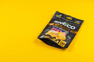 Lviv Ukrayna 04.02.25 sağlıklı bir aperatifin renkli ambalajı canlı sarı bir yüzeyde bulunur. Tasarım, düşük karbonhidrat ve keto dostu özelliklerini vurgulayan açık etiketleme özelliklerine sahiptir..