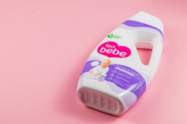 Lviv Ukrayna 04.02.25 Bir şişe Teo Bebe bebek çamaşır deterjanı yumuşak pembe bir yüzeyde duruyor. Tasarımda dostane renkler ve nazik temizlik seçenekleri arayan ebeveynlere yönelik net bir etiket yer alıyor..
