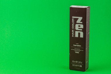 24.03.25 Lviv Ukrayna Zen saç rengi kutusu keratin canlı yeşil arka plana karşı dik duruyor. Paket, canlı saç sonuçları için amonyaksız formülünü vurguluyor..