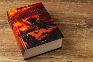 25.03.25 Lviv Ukrayna. Harry Potter kitaplarından oluşan bir koleksiyon, ahşap bir masada duruyor. Ayırt edici kapakta dramatik renkler ve görüntüler, büyüleyici sihir ve macera hayranları yer alıyor..