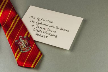 25.03.25 Lviv Ukrayna 'da kırmızı ve altın çizgili bir kravat Hogwarts' tan Bay H Potter 'a yazılmış bir mektubun yanında duruyor..
