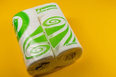Lviv Ukrayna 04.02.25. Parlak sarı arkaplana karşı canlı yeşil ve beyaz bir tasarım içeren iki rulo kağıt havlu bir arada paketlenmiştir. Mutfak temizliği için ideal.