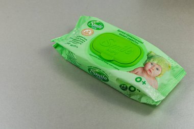Lviv Ukrayna 04.02.25 Gri bir yüzeyde yeşil bir ıslak mendil paketi bulunuyor. Paketleme, bebekler için uygun bir oyun tasarımı içeriyor, onun nazik temizlik özelliklerini vurguluyor.