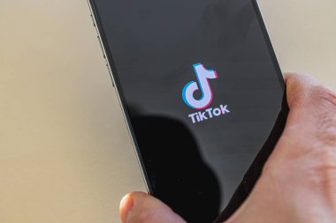 03.26.25 Lviv Ukrayna Bir kişi popüler bir mobil uygulama logosunu gösteren bir akıllı telefon tutuyor, muhtemelen gün ışığında sosyal medya içeriğine bağlanıyor.