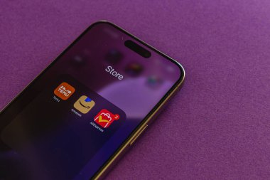 03.26.25 Lviv Ukrayna. Bir akıllı telefon, üç görünür uygulama ve tebligat içeren, faaliyet ve ilgi gösteren bir uygulama mağazasını gösteren parlak mor bir yüzeye dayanır..