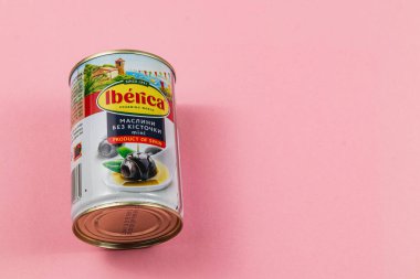Lviv Ukrayna 04.02.25 Pembe arka planda bir teneke zeytin duruyor. Konserve, canlı bir tasarıma sahip ve orijinalliğini sergileyen İspanya 'dan bir ürün..