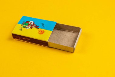 Lviv Ukrayna 04.02.25 Çizgi film karakterlerinin yer aldığı renkli bir kibrit kutusu canlı sarı bir yüzey üzerinde duruyor, oyuncu tasarımlar ve nostaljik bir cazibe sergiliyor, koleksiyoncular için mükemmel..