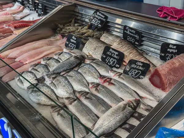 Lviv Ukrayna 02.04.25 Dolu bir deniz ürünleri pazarı çeşitli balık ve kabuklu deniz ürünleri sergiliyor. Yeni avlar düzgün bir şekilde düzenlenir, fiyatlar karatahtallarda sergilenir, müşterileri davet edilir..