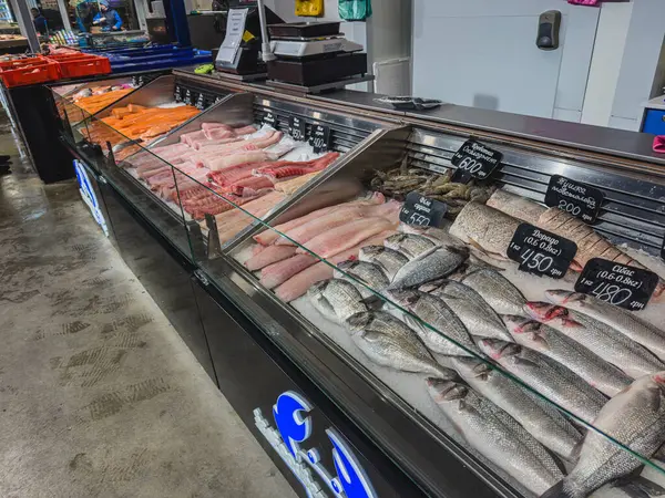 Lviv Ukrayna 02.04.25 Yerel bir pazarda satılık taze balık ve deniz ürünleri seçimi. Sabahın erken saatlerinde cam kılıflarla çeşitli balık türleri sergileniyor..