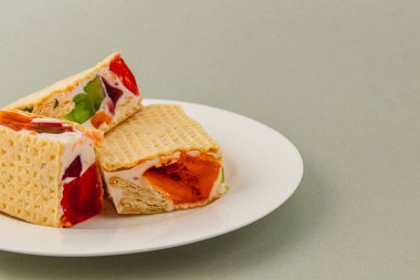 Lezzetli jöleli waffle kekleri içinde krema, yoğurt ve çilek gibi çeşitli meyveler, ferahlatıcı bir tatlı için mükemmel..