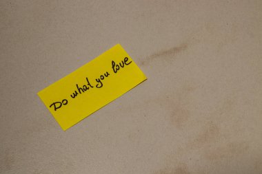 Parlak sarı yapışkan bir nota, birinin tutkularının peşinden gitme konusunda ilham verici bir mesaj içeriyor. Bu basit hatırlatma, günlük hayatta motivasyonu çağrıştırıyor..