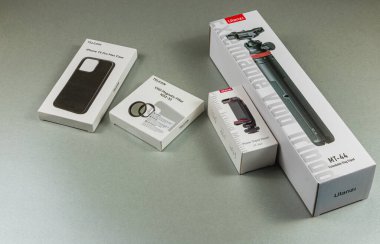 Lviv Ukrayna 05.04.25 Gri bir yüzeyde bir tripod, bir telefon kılıfı ve bir telefon kabini de dahil olmak üzere çeşitli kamera aksesuarları değerlendirmeye ve kullanılmaya hazırdır..