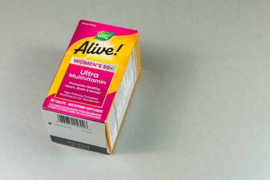 Lviv Ukrayna 10.04.25 Parlak renkli kadın multivitaminlerinin olduğu kutu gri bir yüzeyde bulunuyor. Kalp ve kemik besinleri de dahil olmak üzere 50 yaşın üzerindeki kadınlar için sağlık faydalarını vurguluyor.