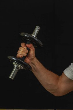 Bir kişi halterle halter kaldırmakla meşgul, spor salonunda güç gösterisi yapıyor. Odaklanan çaba fitness ve adanmışlığı vurguluyor.