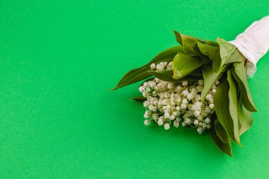 Vadinin narin bir zambak buketi canlı yeşil bir yüzeye dayanır. Büyüleyici beyaz çiçekleri ve taze yeşil yaprakları doğal bir düzende sergilenir..