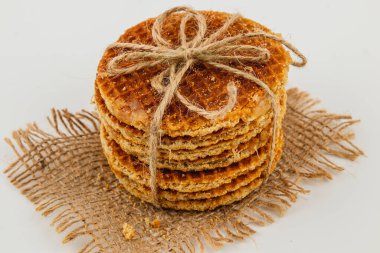 Yığılmış karamel waffle 'ları sicimle güzelce bağlanır ve ulusal karamel gününü kutlamak için çuval bezi üzerine yerleştirilir. Sıcak altın rengi hoşgörüyü ve zevki davet eder..