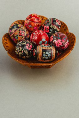 Karmaşık tasarlanmış bir Paskalya yumurtası koleksiyonu el yapımı bir kasede duruyor. Yumurtalar canlı desenler ve renkler sergiliyor. Şenlikli dekorasyonlar için mükemmel..